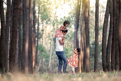 Surface level view of father with daughters in forest
