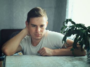Portrait of young woman sitting on table