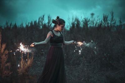 Woman standing on field in forest