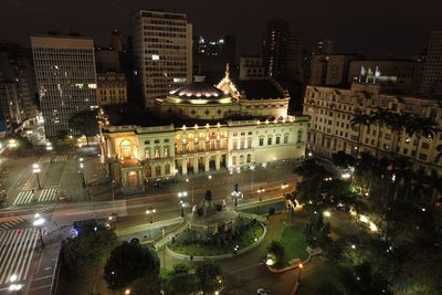 High angle view of illuminated street amidst buildings at night