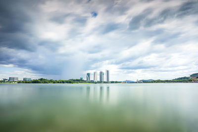 View of buildings in lake against cloudy sky