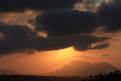 Scenic view of silhouette mountains against sky at sunset