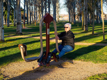 Full length of senior woman exercising at playground