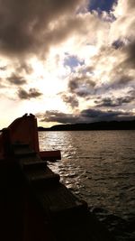 Pier on sea against cloudy sky