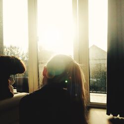 Rear view of man and woman looking through window