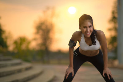 Portrait of young woman exercising during sunset