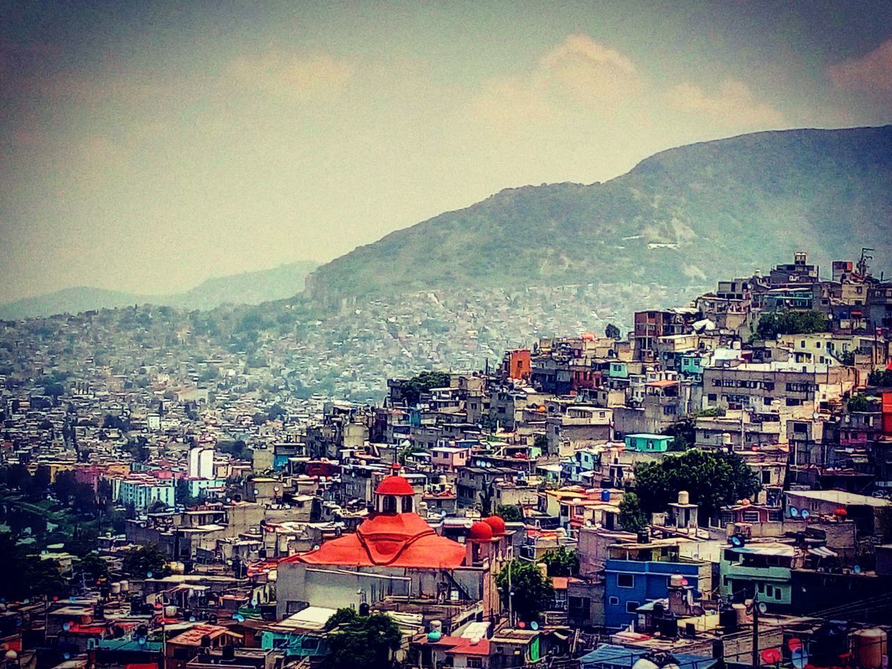 HIGH ANGLE VIEW OF TOWNSCAPE AND MOUNTAINS AGAINST SKY