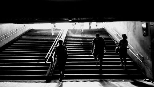 Rear view of people walking on stairs