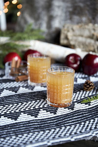 Apple spiced cider served on ice with apple and cinnamon