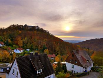 High angle view of houses and buildings against sky during sunset