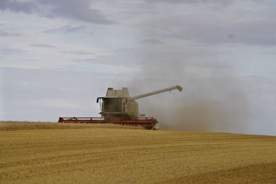 Traditional windmill on field against sky