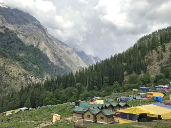 Houses by trees and mountains against sky