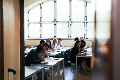 Multi-ethnic students sitting at desks during language class