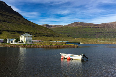 Scenic view of lake by buildings against sky