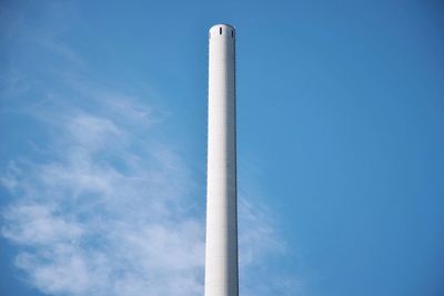 Low angle view of smoke stack against clear blue sky