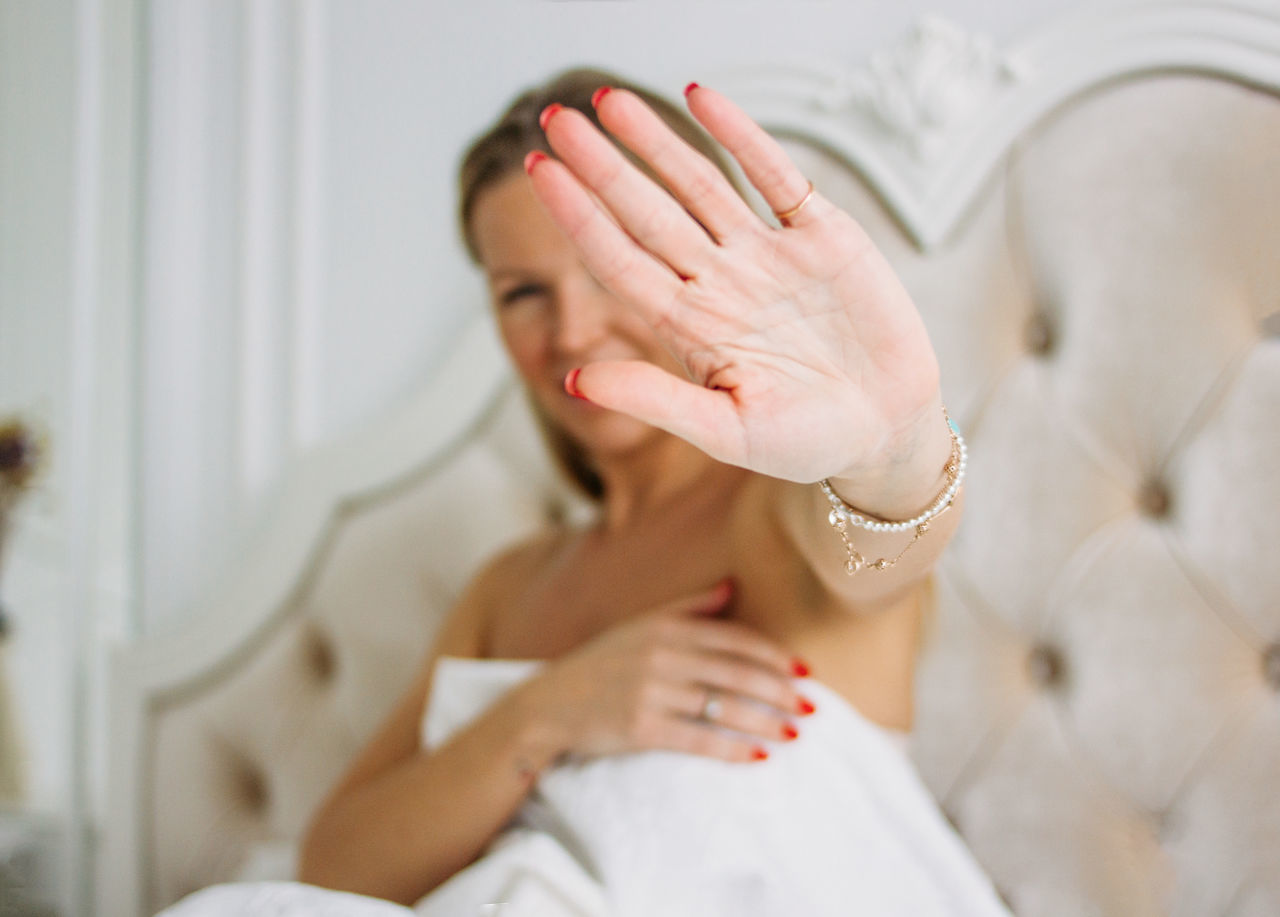 MIDSECTION OF WOMAN LYING ON BED