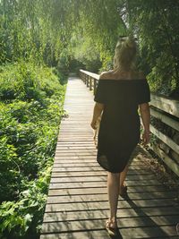 Rear view of woman walking on footpath