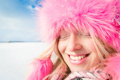 Portrait of young woman with pink hat against sky