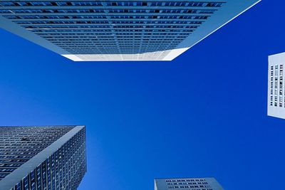 Low angle view of skyscraper against clear blue sky