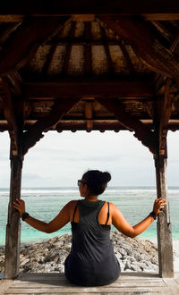 Rear view of woman standing at beach