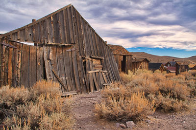 Abandoned house on field against sky