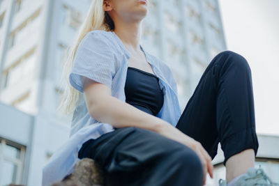 Low angle view of woman sitting outdoors