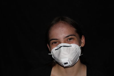 Portrait of mid adult woman against black background