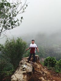 Man standing on rock against mountain