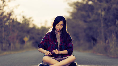 Portrait of a young woman sitting outdoors