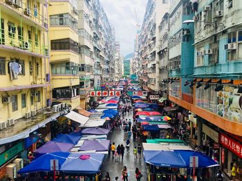 High angle view of people on street market amidst buildings in city