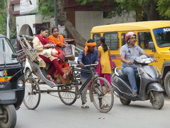 People riding motorcycle on road in city