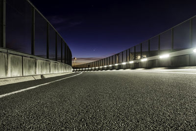 Surface level of illuminated bridge against sky at night