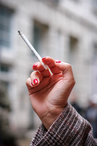 Cropped hand of woman holding cigarette
