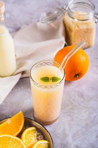 Diet orange smoothie with rice milk in a glass on the table vertical view