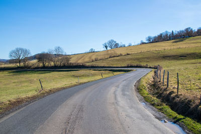 Road amidst field against sky