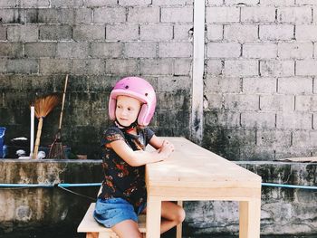 Girl wearing helmet while sitting at table
