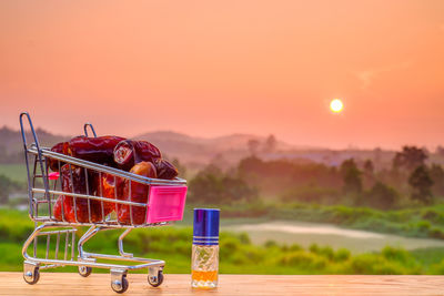 Close-up of orange fruit on table against sky during sunset