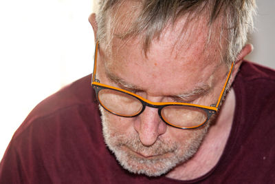 Close-up portrait of man wearing eyeglasses against white background