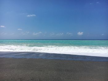 Scenic view of beach against blue sky