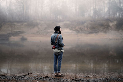 Rear view of boy standing on lake