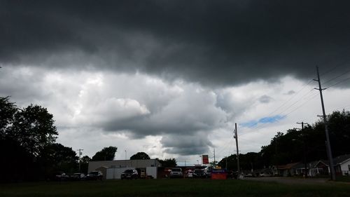 Electricity pylon against cloudy sky