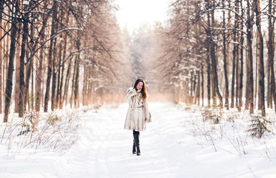 Full length of woman standing on snow covered land