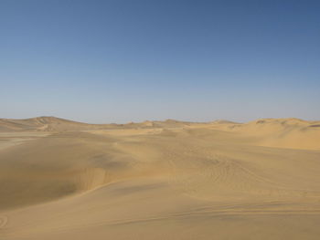 Scenic view of desert against clear blue sky