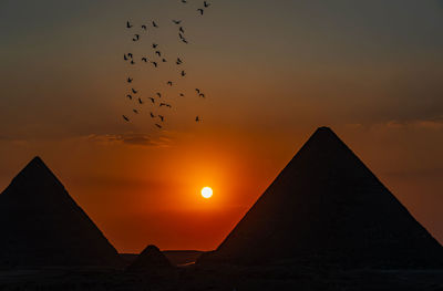 Low angle view of silhouette buildings against sky during sunset