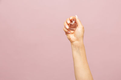 Cropped hand of woman against white background