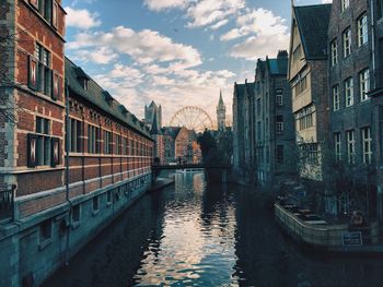 River amidst buildings against cloudy sky