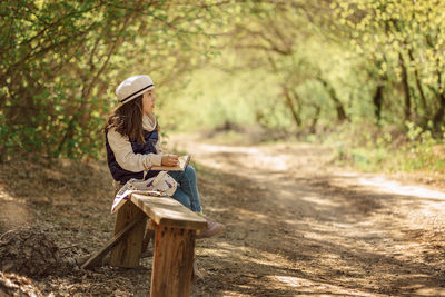 Little girl paints in open air in spring blooming fairytale park. children's drawings. creative kid. 