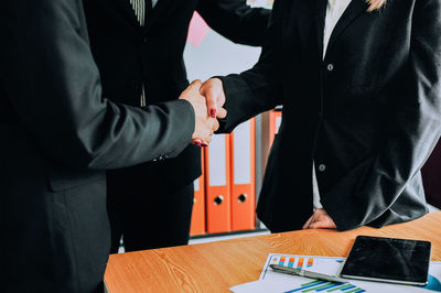 Midsection of man and woman standing on table