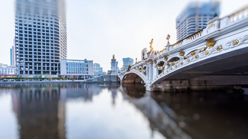 Bridge over river with buildings in background