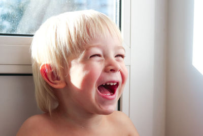 Happy child in home quarantine playing and laughing at the window. stay home concept.